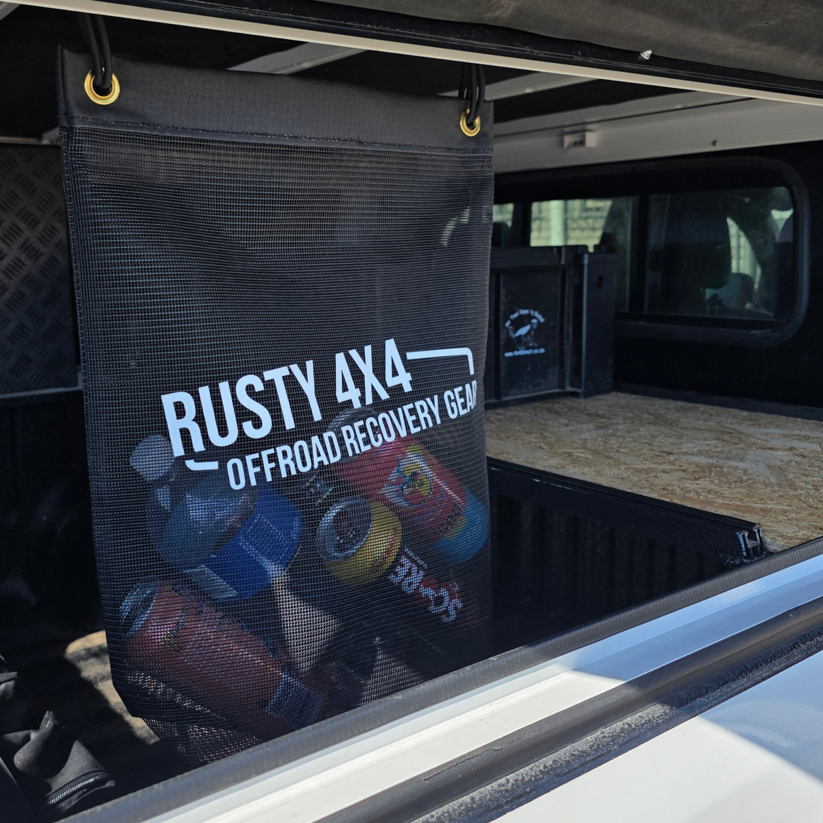 Black mesh storage bag with Rusty 4x4 branding, suspended by yellow hooks.
