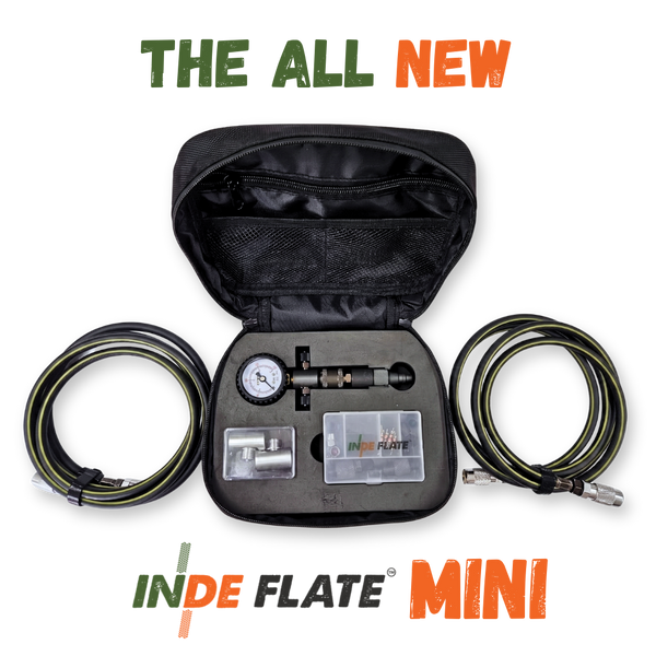 Portable tire inflator kit with open black case, gauge, and coiled hoses