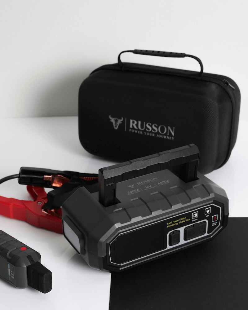 Russon 12V jump starter with black carrying case and visible port panel, connected cables